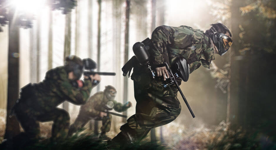 Paintball team in action rainy forest