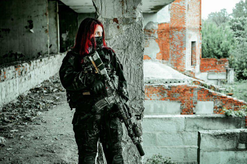 airsoft woman in uniform with tactical gear and airsoft machine gun