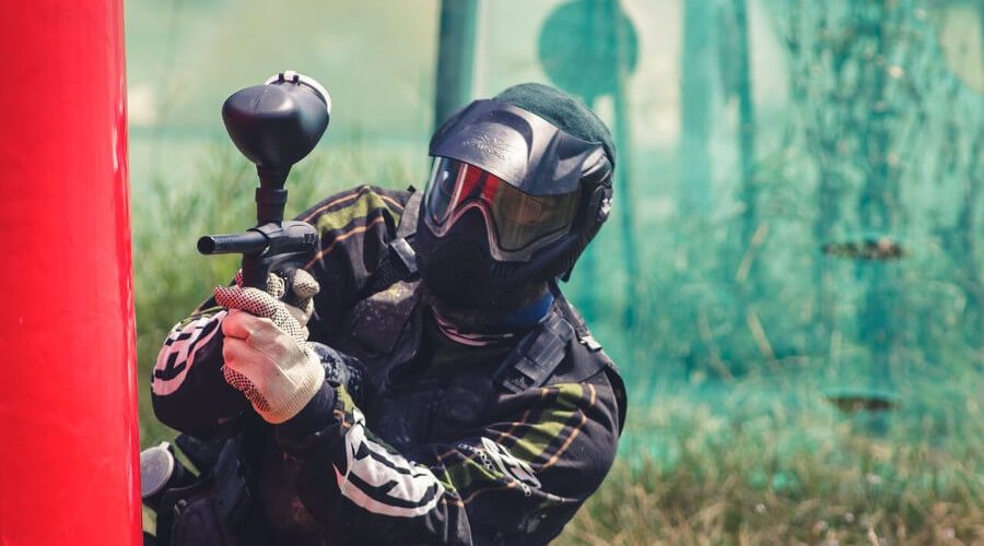 man holding paintball marker and playing woodsball