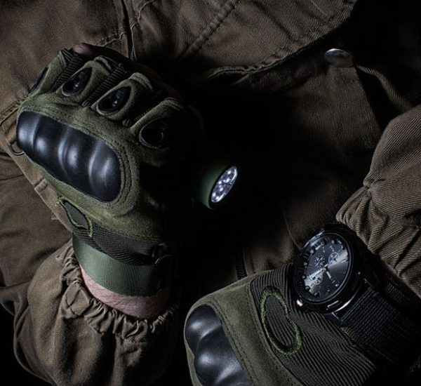 person in brown tactical jacket and shooting gloves