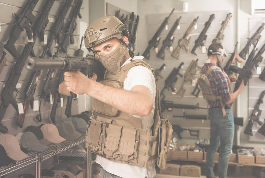 two guys in military equipment with rifle in airsoft shop