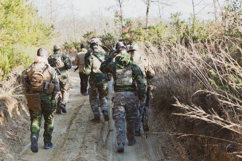 airsoft military game players in camouflage uniform