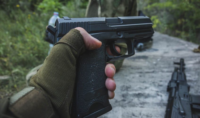 man holding in hand airsoft green gas pistol