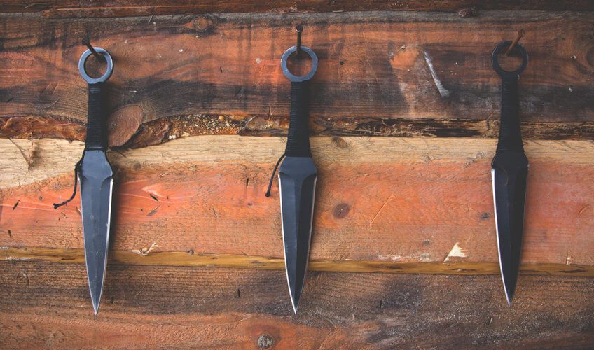 three throwing knives on table